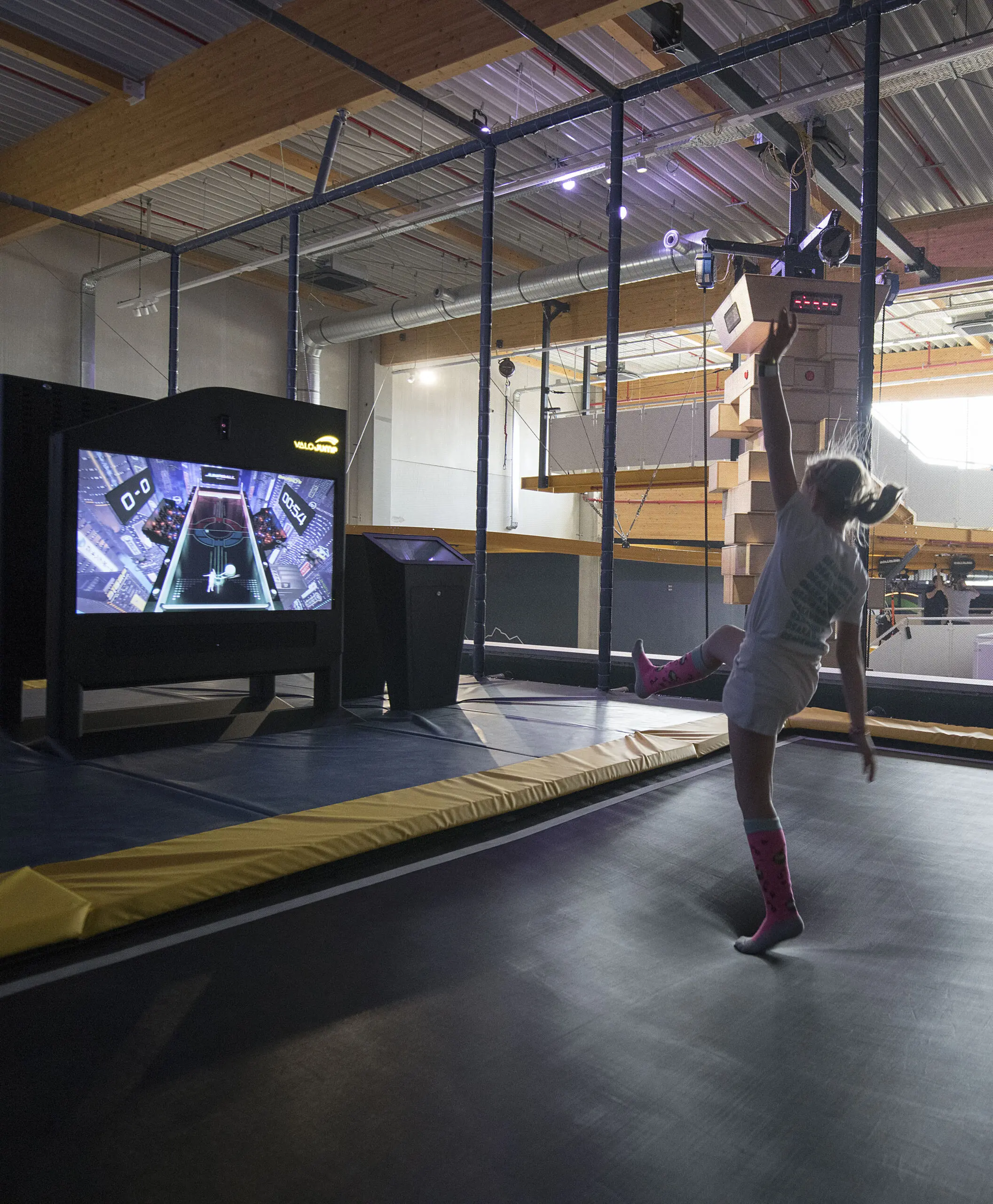 Meisje springt op een interactieve trampoline voor een gamescherm