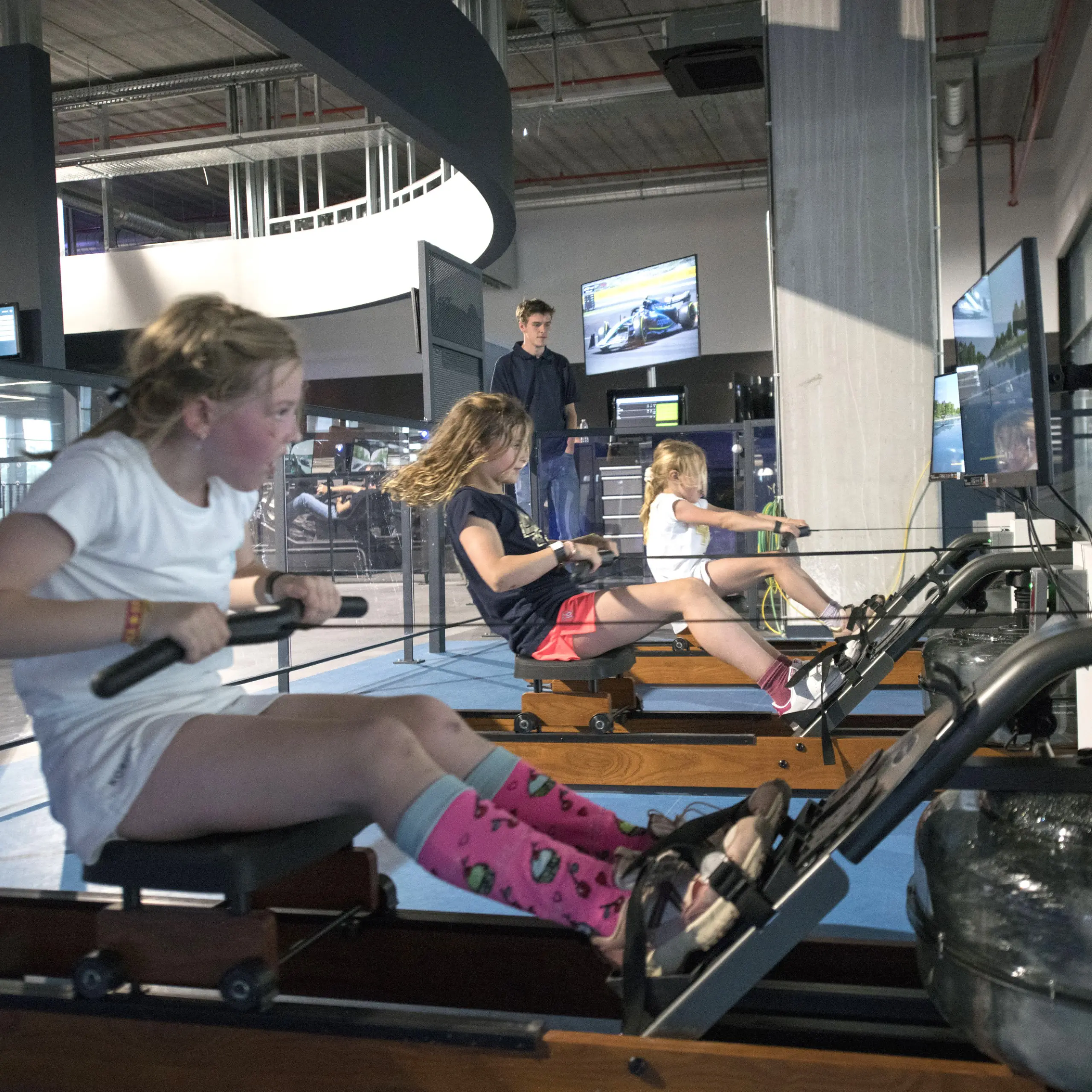 Vrouwen roeien naast elkaar op de roeisimulators