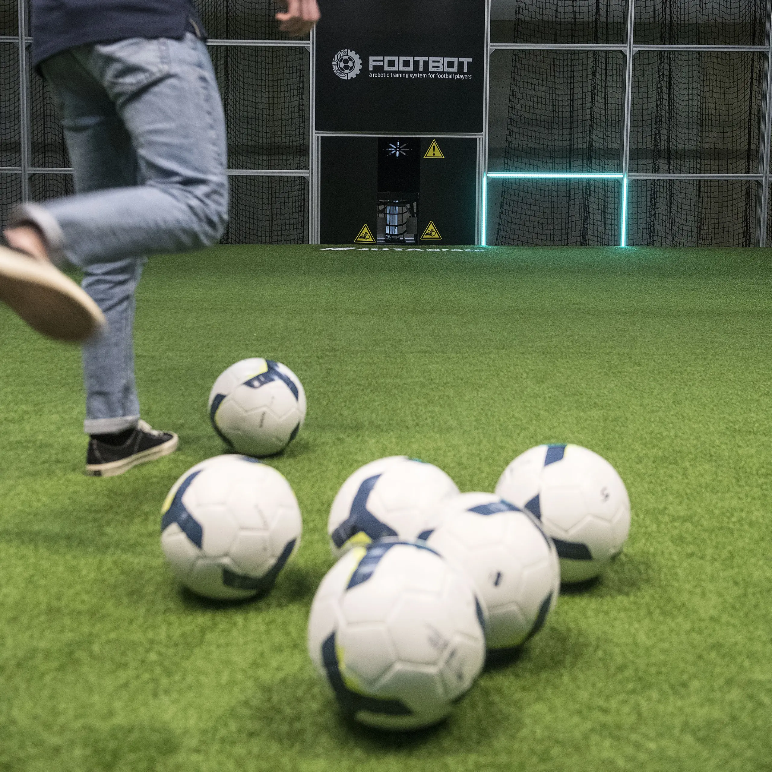 Speler trapt een bal tussen de voetballen in de Footbot