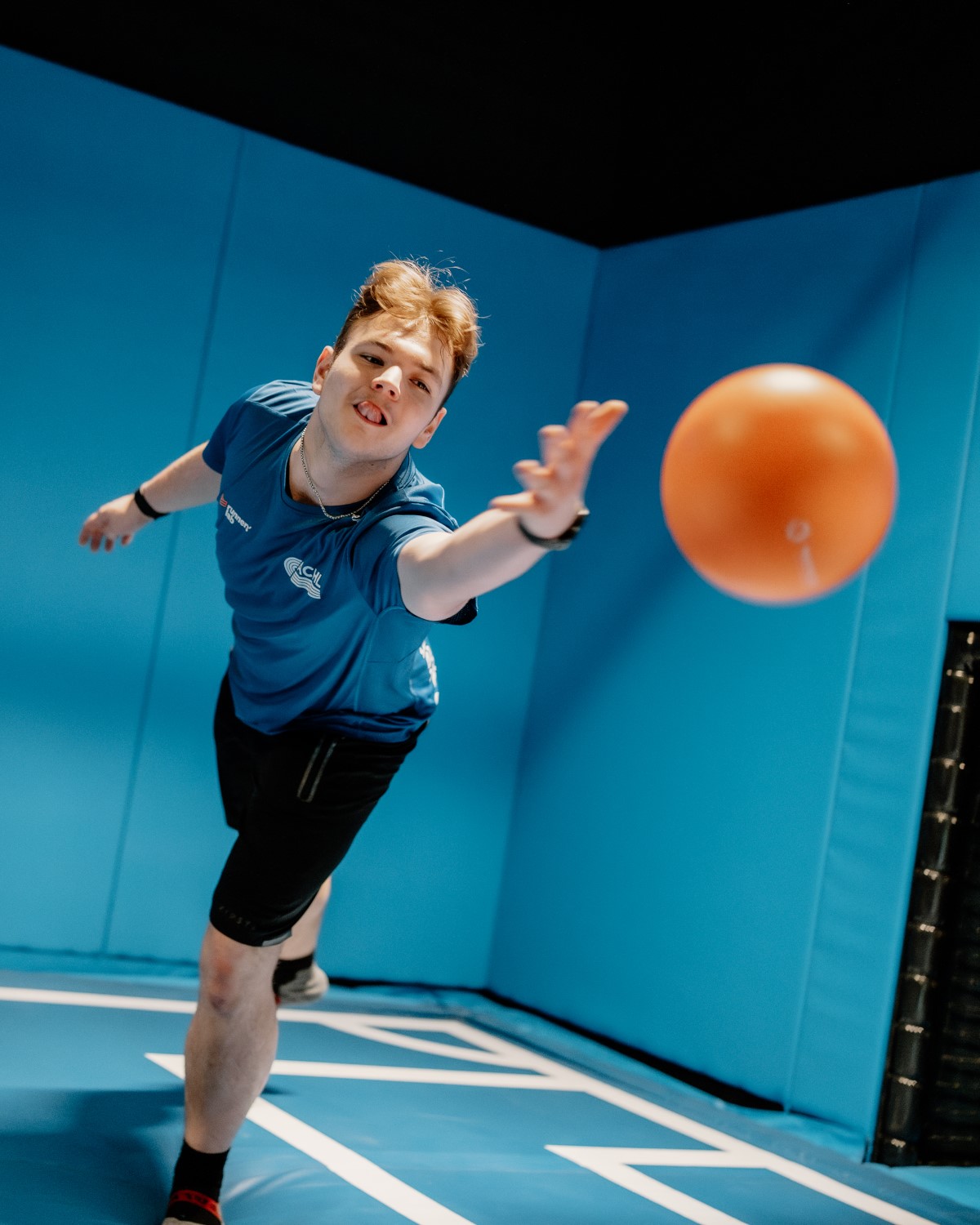 Jongen trapt een oranje bal in de blauwe Airtrack Arena