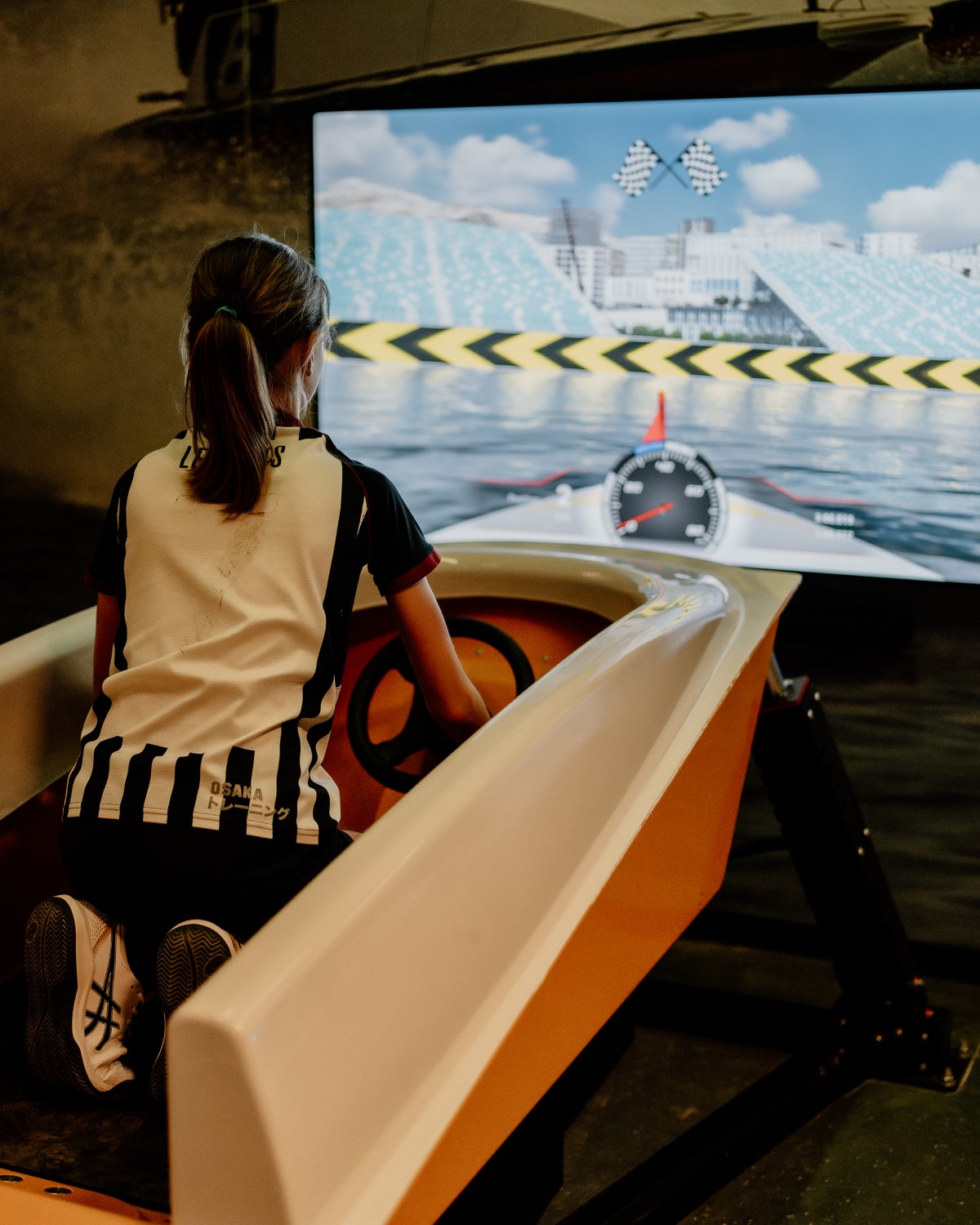 Meisje stuurt haar speedboot in de kyotei-simulator