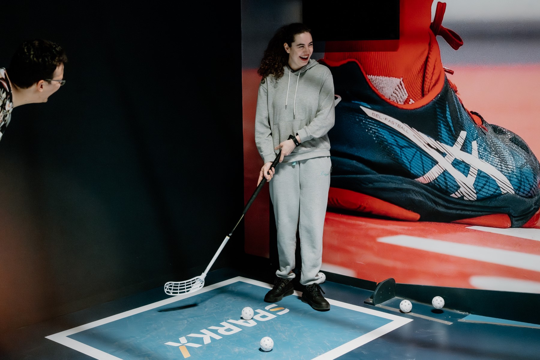 Vrouw mikt met haar stick op de bal op het floorballveld
