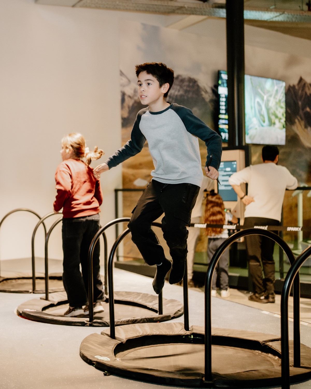 Jongen springt op een kleine trampoline voor een gamescherm