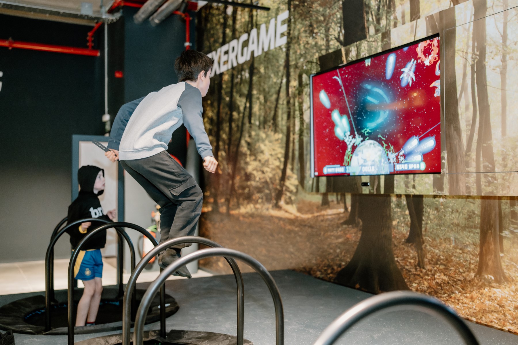 Kinderen springen op trampolines voor een scherm met een interactieve game