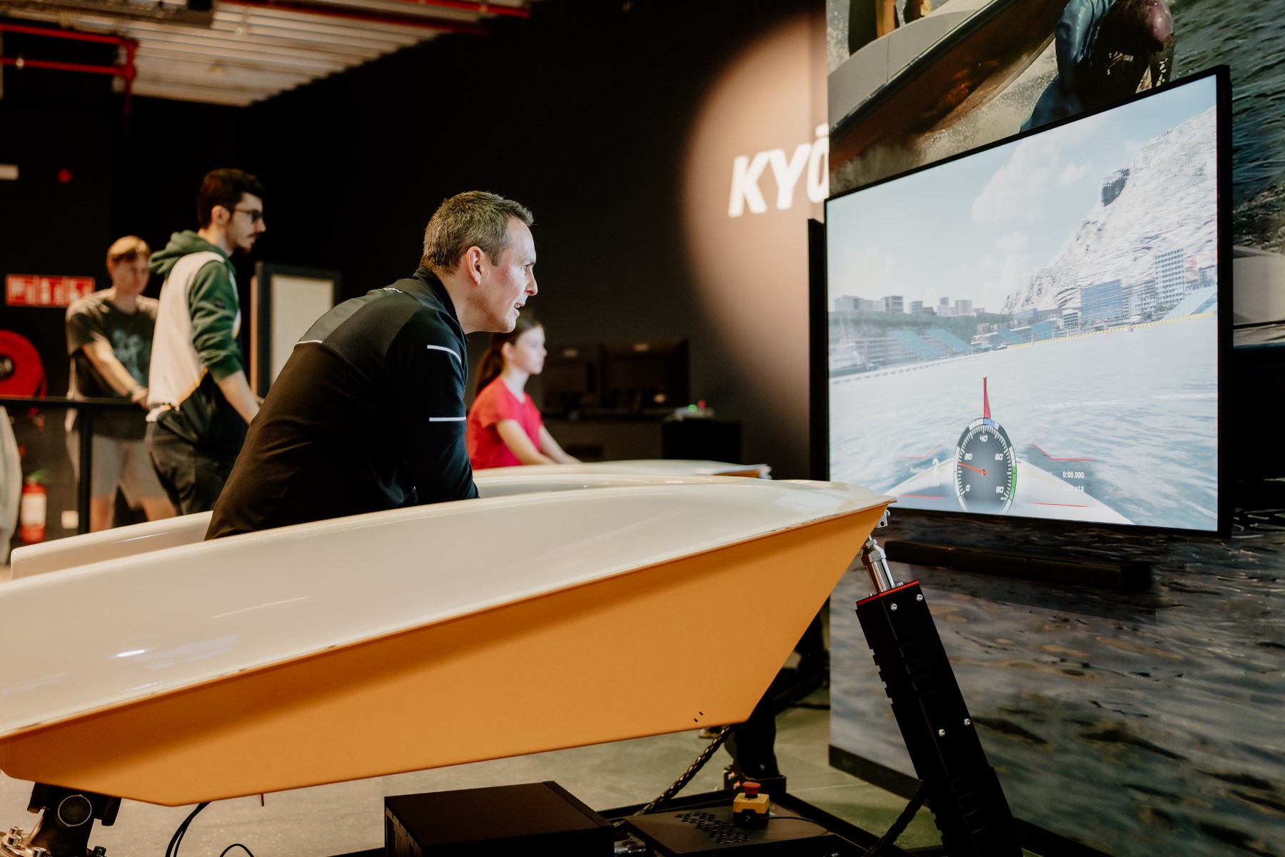 Deelnemer volgt de race op het scherm vanuit zijn boot